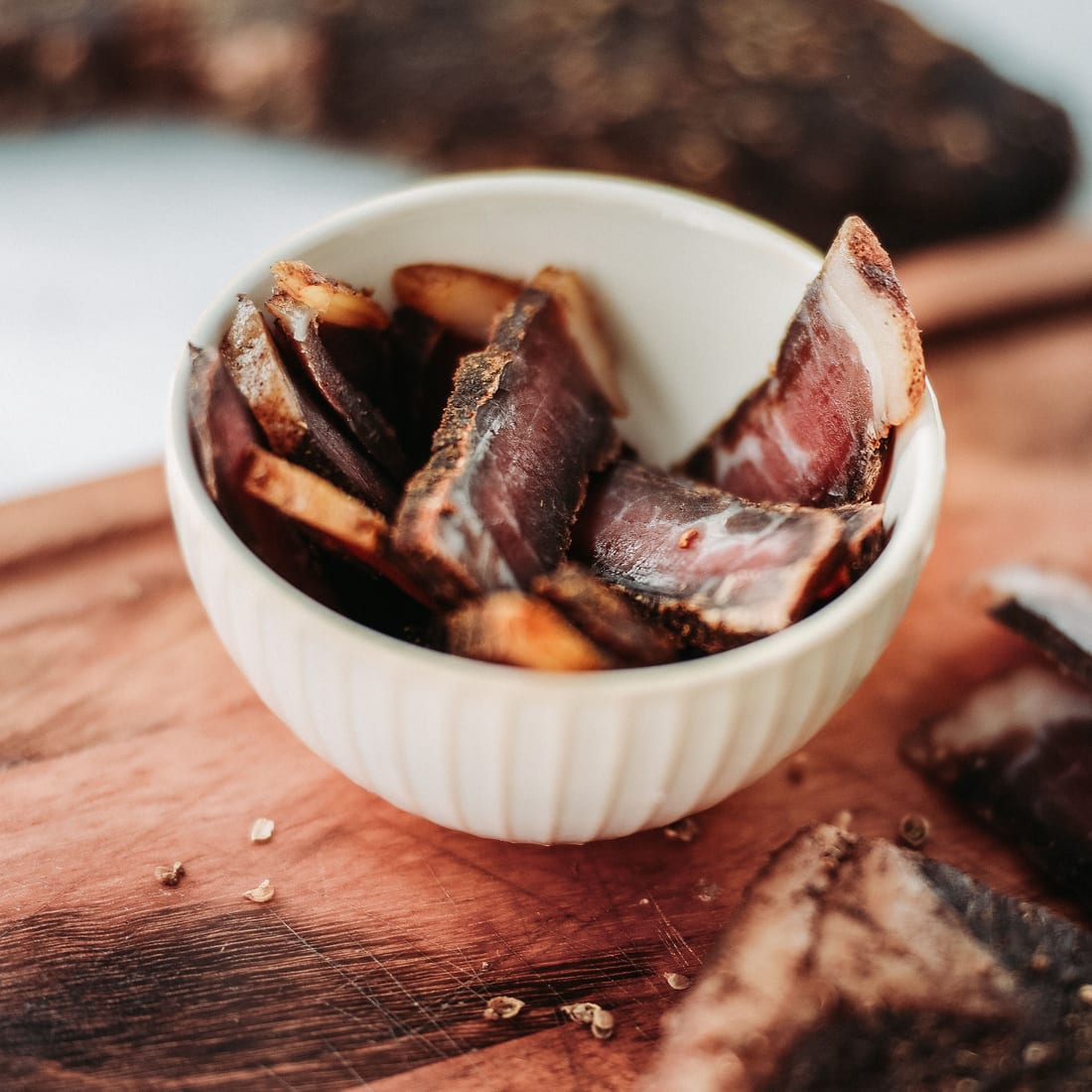 Hand-cut beef biltong slices on a wooden board